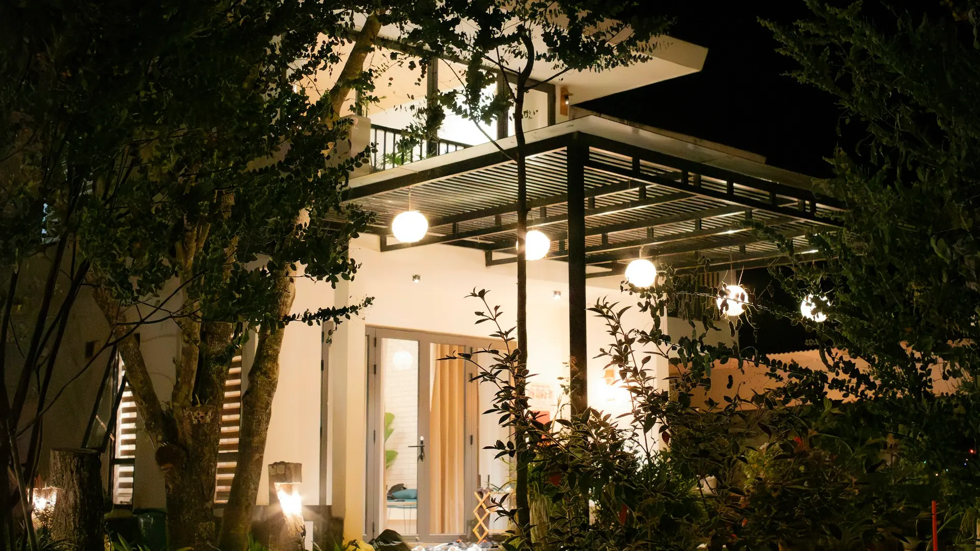 Moderne woning in de avond met buitenverlichting langs gevel en oprit