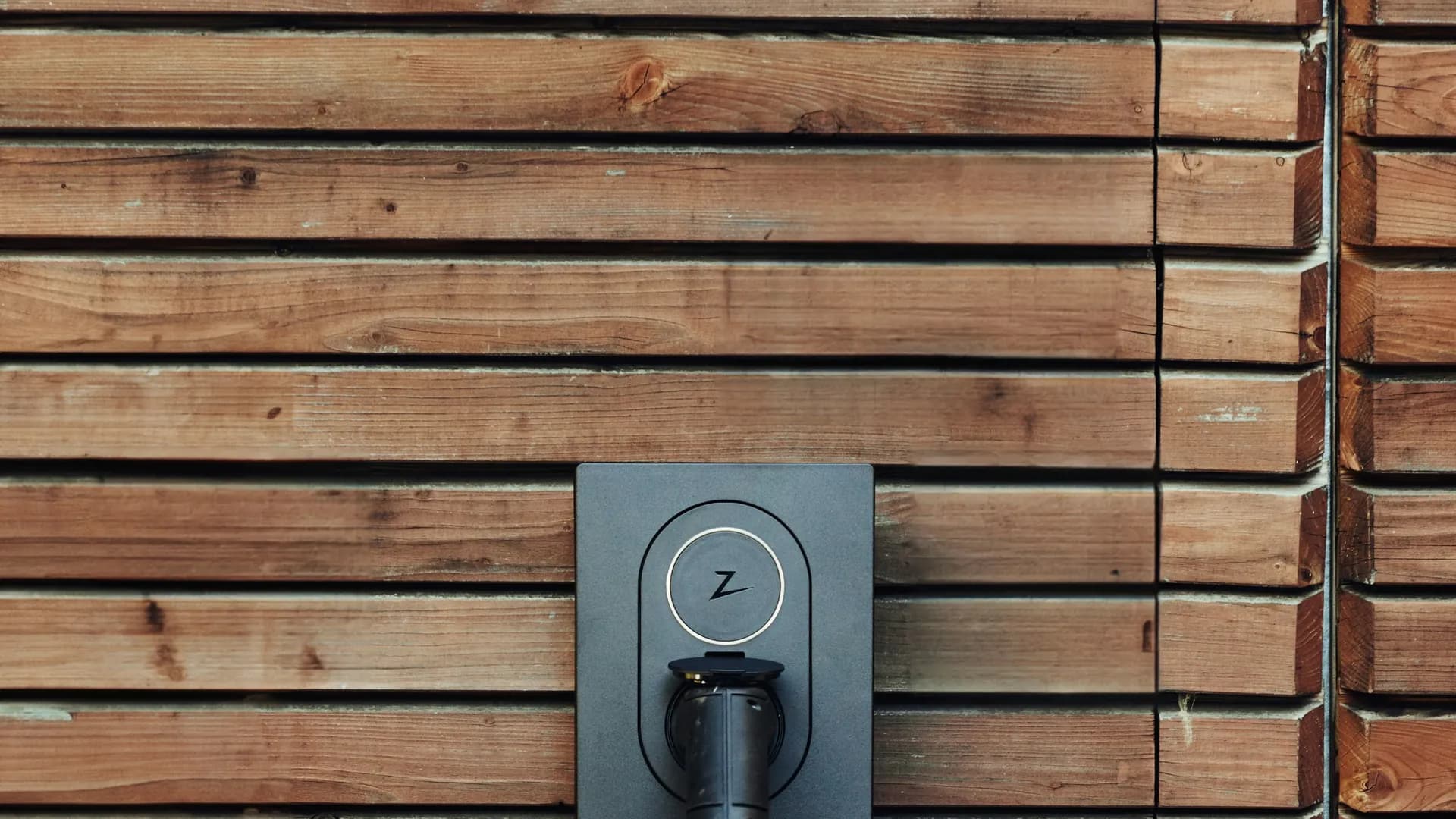 Laadpaal voor een elektrische auto, gemonteerd aan de gevel van een woning